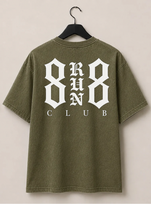 An olive green short-sleeve t-shirt shown from both front and back, hanging on black hangers against a light beige wall. The front features a small white graphic on the left chest, and the back features a large white graphic reading '8 RUN 8 CLUB'.
